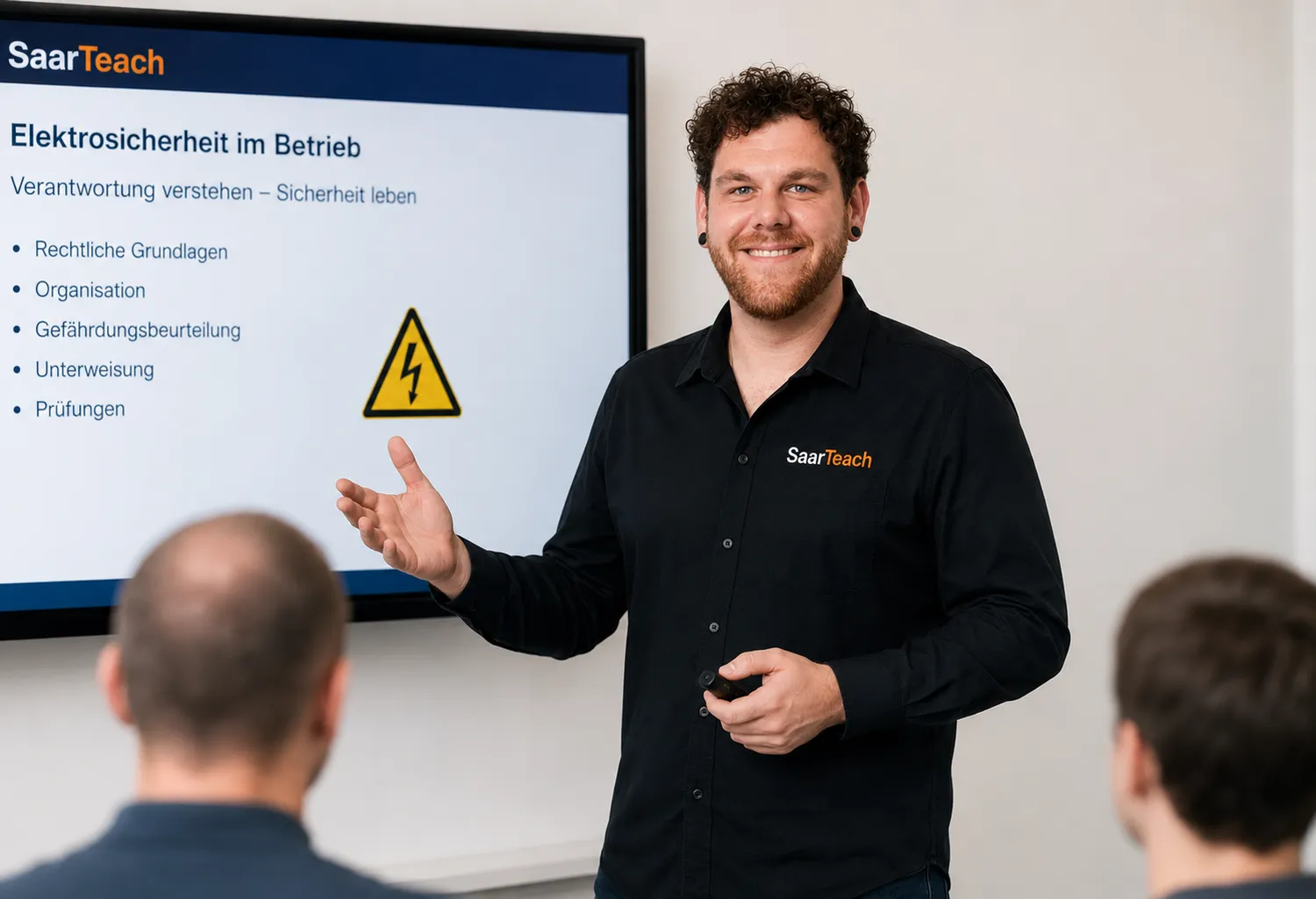 SaarTeach - Dozent für elektrotechnik und arbeitschutz - Thorsten Zimmer präsentiert einem Publikum eine Folie zum Thema elektrische Sicherheit am Arbeitsplatz.